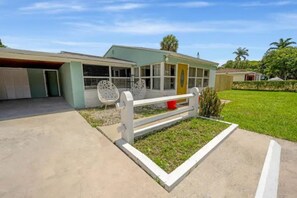 Ein eingeschossiges Haus mit Garage, überdachter Veranda und kleinem Garten.