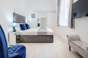 Relax in a spacious room with a large bed, bedside table, and flat-screen TV.