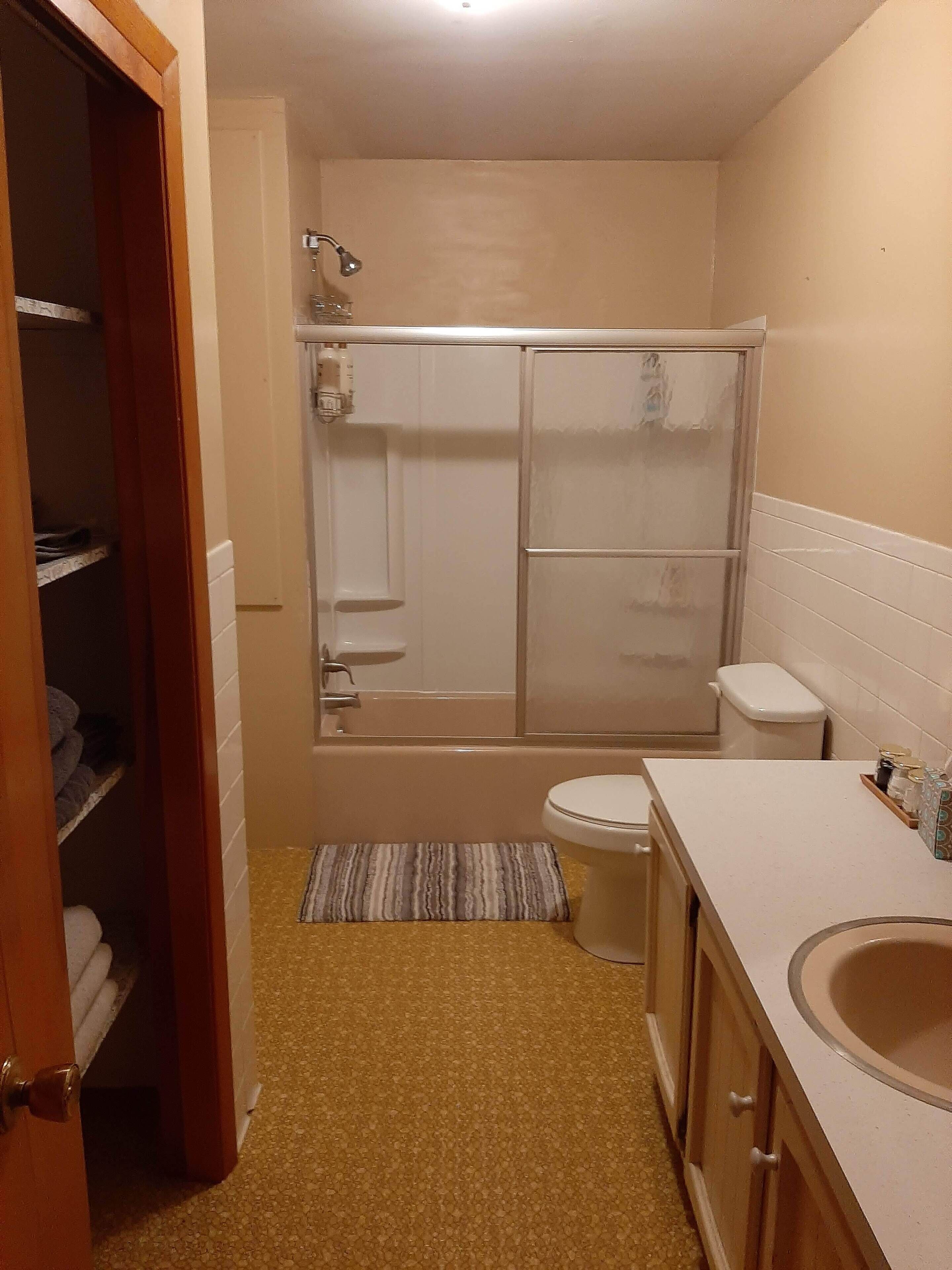 Une petite salle de bain comprenant une douche, des toilettes et un lavabo.