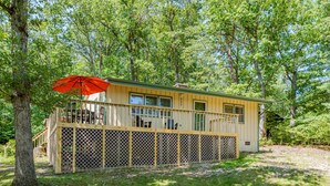 Une cabane avec une terrasse, un parasol rouge et le numéro 235 peint sur le côté.