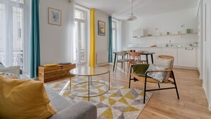Moderni olohuone, jossa on sohva, pyöreä sohvapöytä ja ruokailutila tuoleineen.