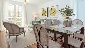 A dining area with a glass table, wicker chairs, and a vase with flowers. - Genteel Home San Antonio IV (Cadiz)