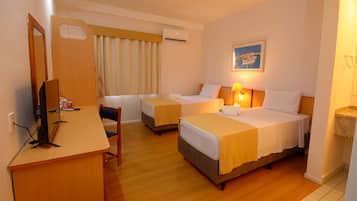 A hotel room with two beds, a desk, a chair, and a television.