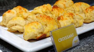 A plate of croissants on a white plate with a sign that reads "Croissant".
