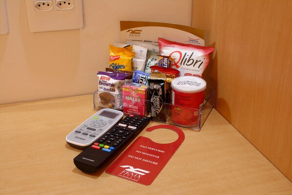 A minibar with snacks, a remote control, and a minibar key card.