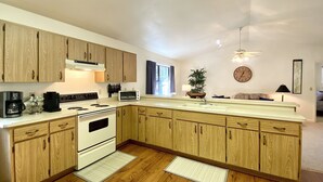 Una cocina moderna con armarios de madera, horno integrado, cafetera y tostadora.