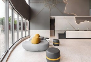 A modern interior with large windows, a reception desk, and unique geometric wall art.