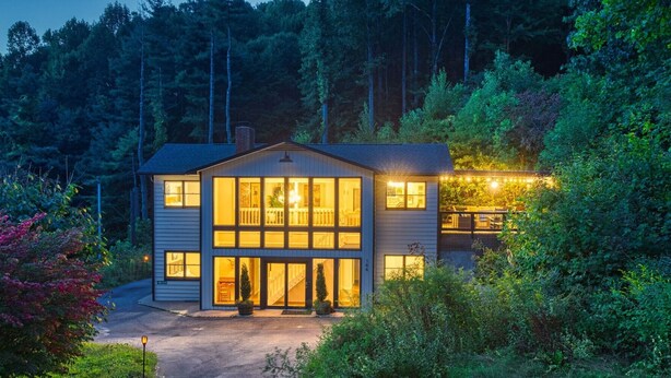 A two-story house with a large front porch, multiple windows, and a deck area. -  Above Asheville, Art House  (Fairview)