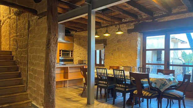 Un intérieur rustique comprenant une cuisine, un coin repas et un escalier.
