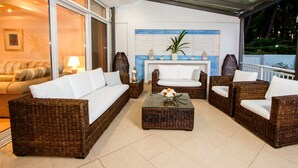 A modern outdoor living area with wicker furniture, a glass ceiling, and a fireplace. - A Private Haven: Hera with Secluded Pool and Garden (Kassandra)