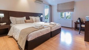 A modern bedroom with a large bed, bedside tables, a window with a view, and an air conditioning unit. - A Private Haven: Hera with Secluded Pool and Garden (Kassandra)