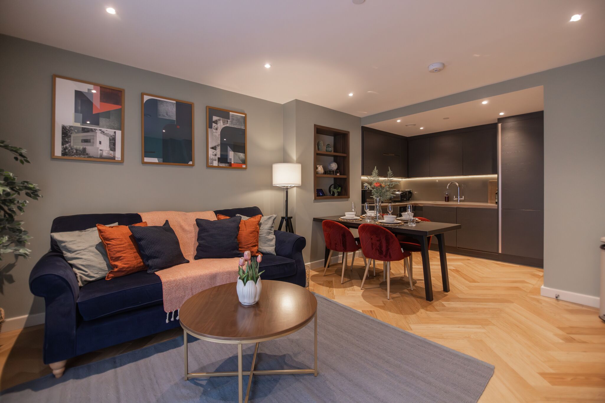 A modern living room with a sofa, coffee table, and dining area.