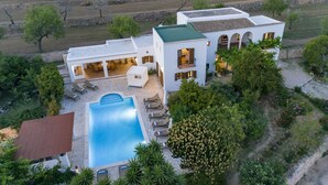 A modern villa with a swimming pool, outdoor seating, and a landscaped garden.