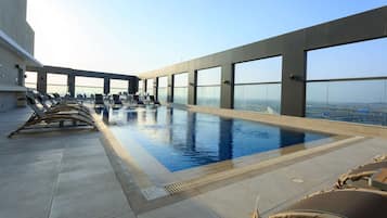 Una piscina al aire libre, sillones reclinables de piscina