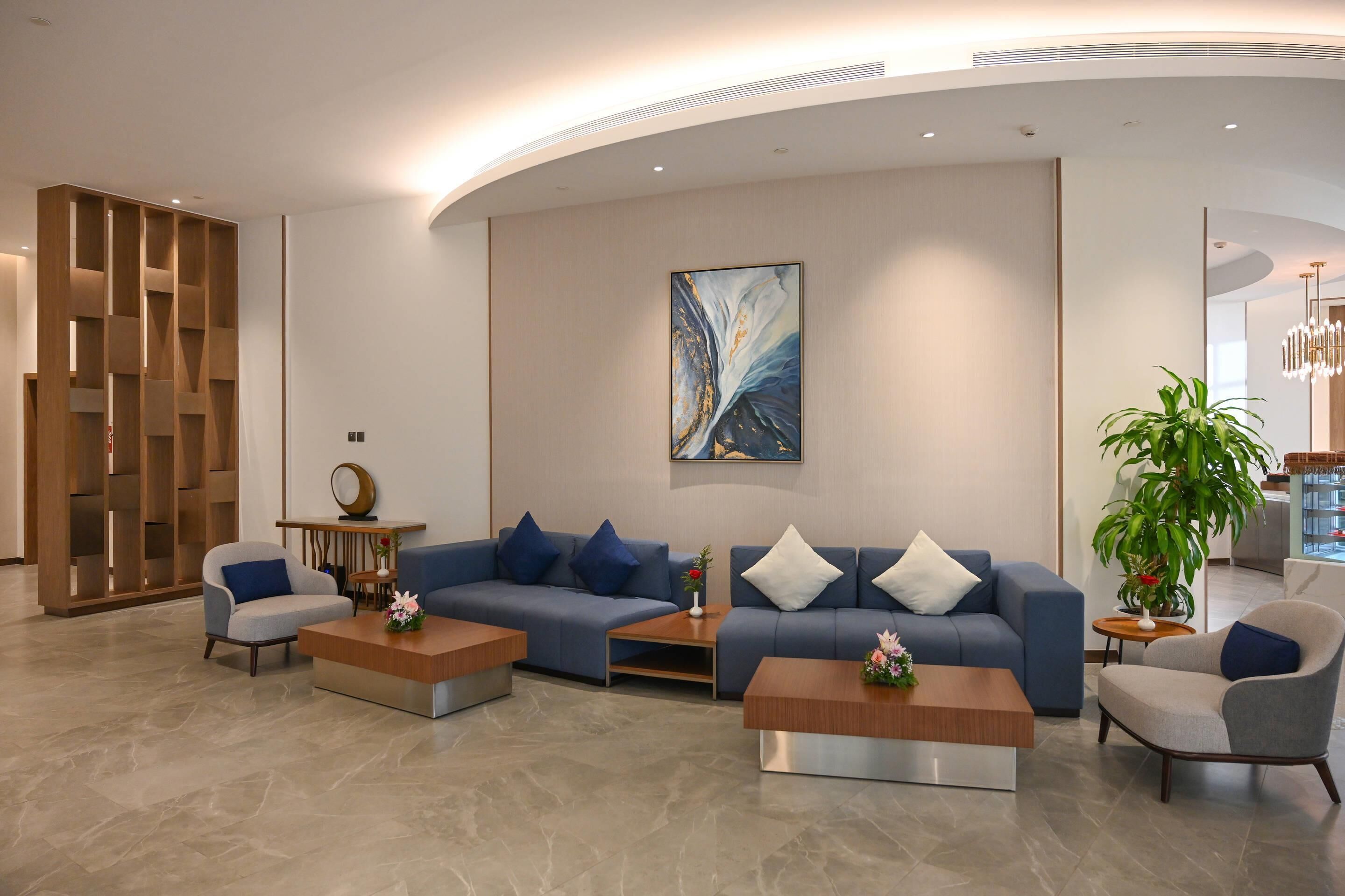 A modern lobby with a sectional sofa, armchairs, and a coffee table.