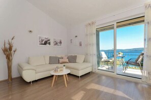 Relax in this stylish living room with a sofa, coffee table, and balcony offering a view of the water.
