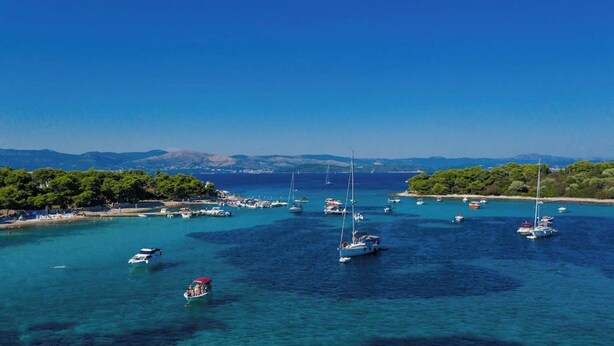 A coastal marina with boats and yachts, surrounded by clear blue waters and green hills in the background. - Fantastic beachfront apartment with private balcony on the Adriatic.Top location (Seget Donji)