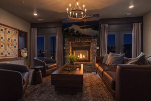 A living room with a fireplace, leather sofas, a coffee table, and a chessboard. - Crown Jewel / Table Rock Lake Views / Near Silver Dollar City / NEWLY REMODELED (Indian Point)