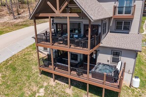 A two-story building with a balcony on the ground floor and a patio area with outdoor seating. - Crown Jewel | Table Rock Lake Views | Sleeps 24 | Near Silver Dollar City (Indian Point)