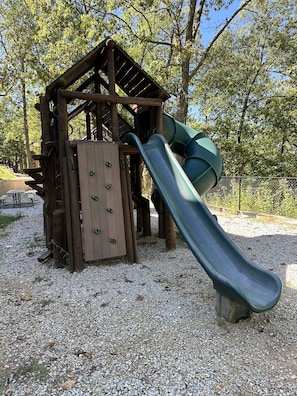 A wooden playground structure with a slide and climbing elements. - Crown Jewel | Table Rock Lake Views | Sleeps 24 | Near Silver Dollar City (Indian Point)