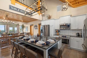 A modern kitchen with white cabinetry, stainless steel appliances, and a central island with seating. - Crown Jewel / Table Rock Lake Views / Near Silver Dollar City / NEWLY REMODELED (Indian Point)