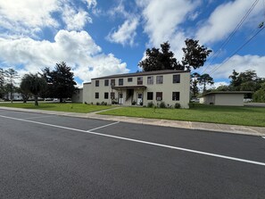 Un bâtiment à deux étages, doté d’un toit plat, d’une entrée principale avec une porte et d’un petit porche.