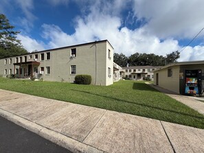 A two-story building with a covered entrance and a vending machine on the right. - Historic Renovated Apartment SGMC Nurses welcome (Valdosta)