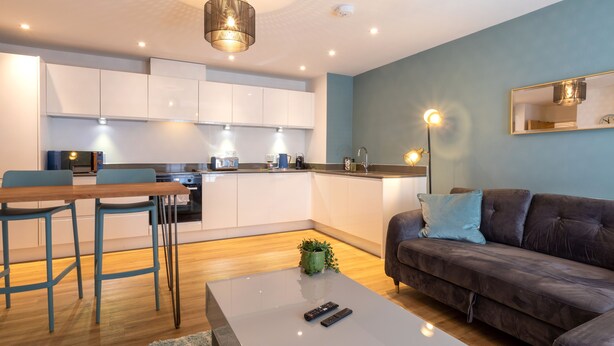A modern living space with a kitchen, dining area, and a sofa.