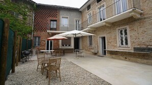 Un patio con mobiliario exterior, una parrilla y una mesa pequeña.