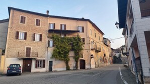 Una calle estrecha con edificios de fachadas de piedra y numerosas ventanas con contraventanas.
