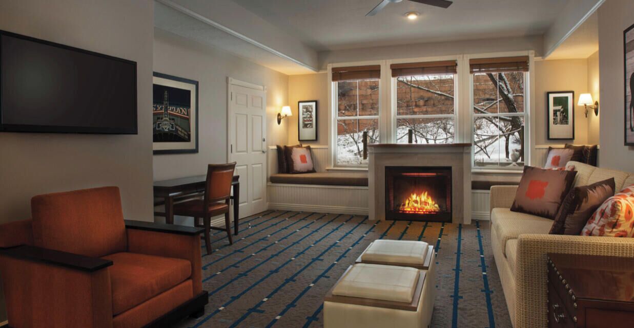 A villa living room with a fireplace, seating area, and a ceiling fan.