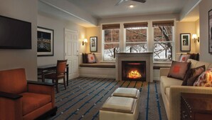 Salón de una villa con chimenea, zona de estar y ventilador de techo.