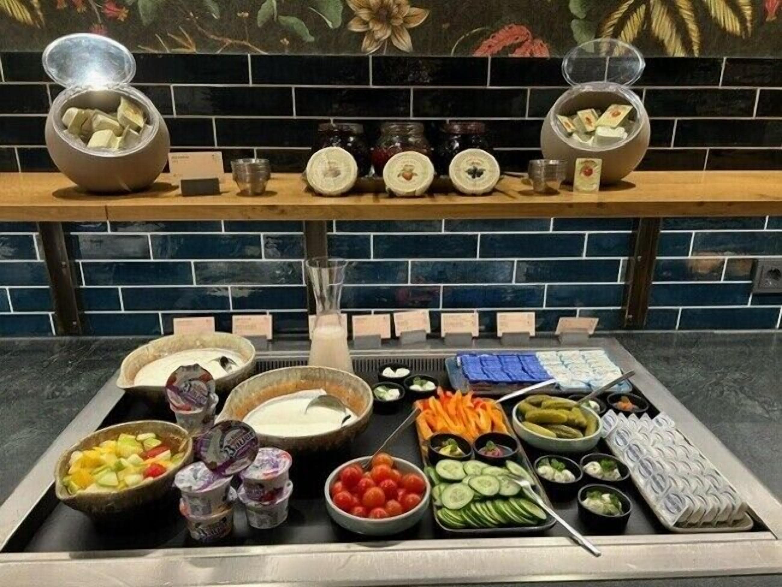 A buffet with various food items including fruits, vegetables, and dips.