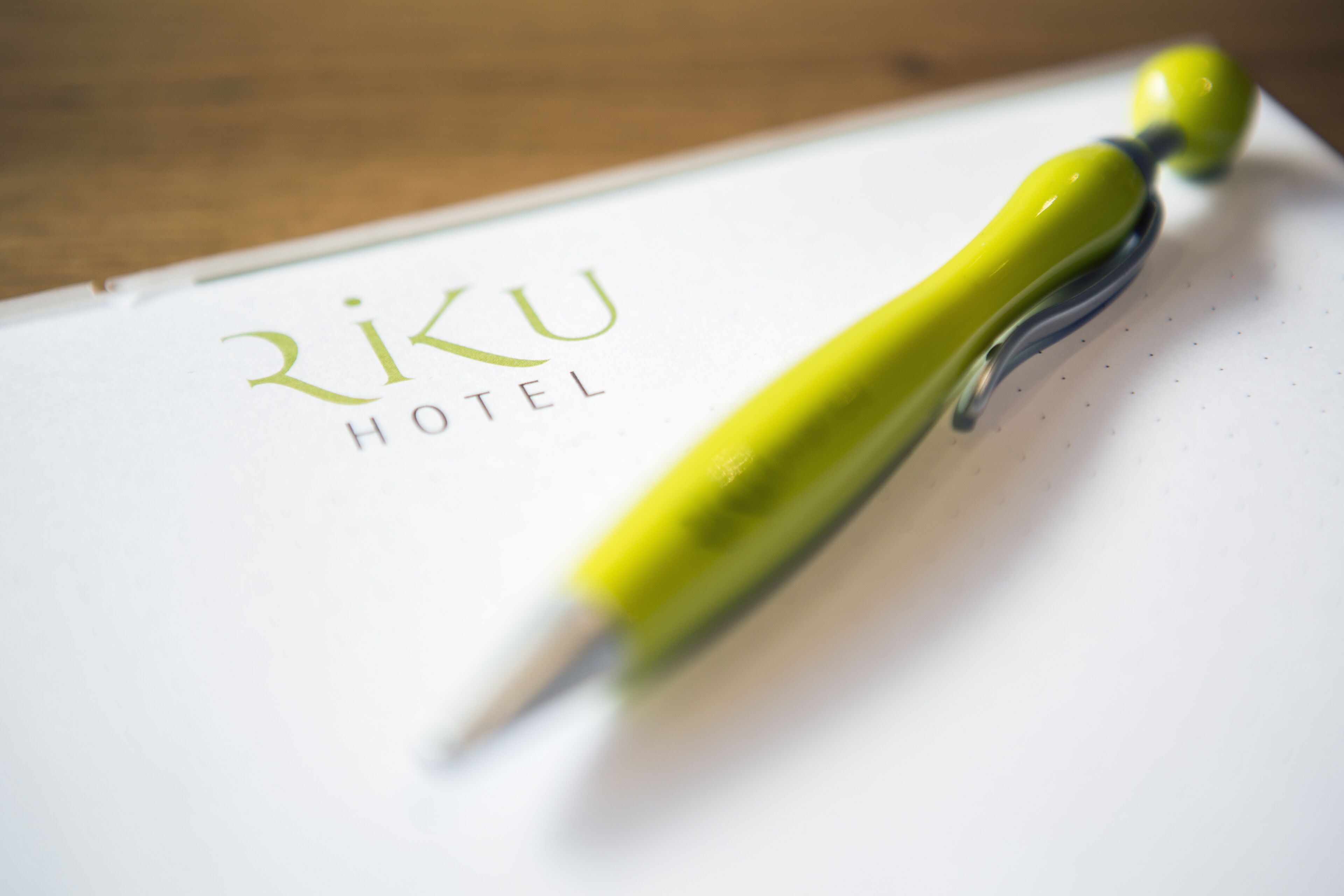 Un bolígrafo sobre un papel con el texto "RIKU HOTEL" a la vista.