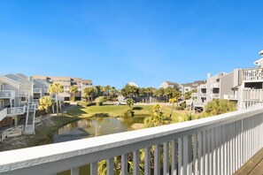 A residential area with multiple buildings, a small pond, and a wooden deck.