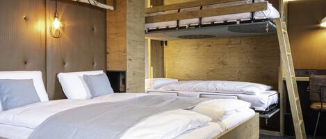 A modern hotel room with a bunk bed, a desk, and a chair.