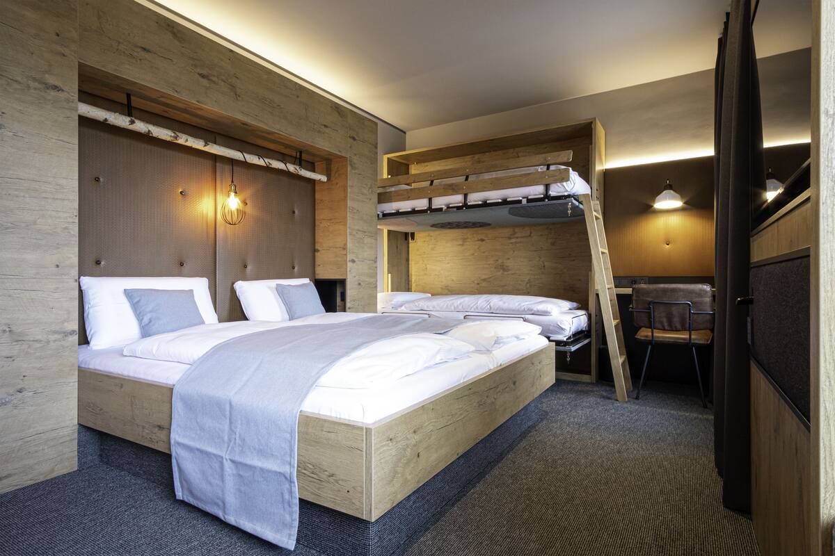 A modern bedroom with a bunk bed, a desk, and a chair.