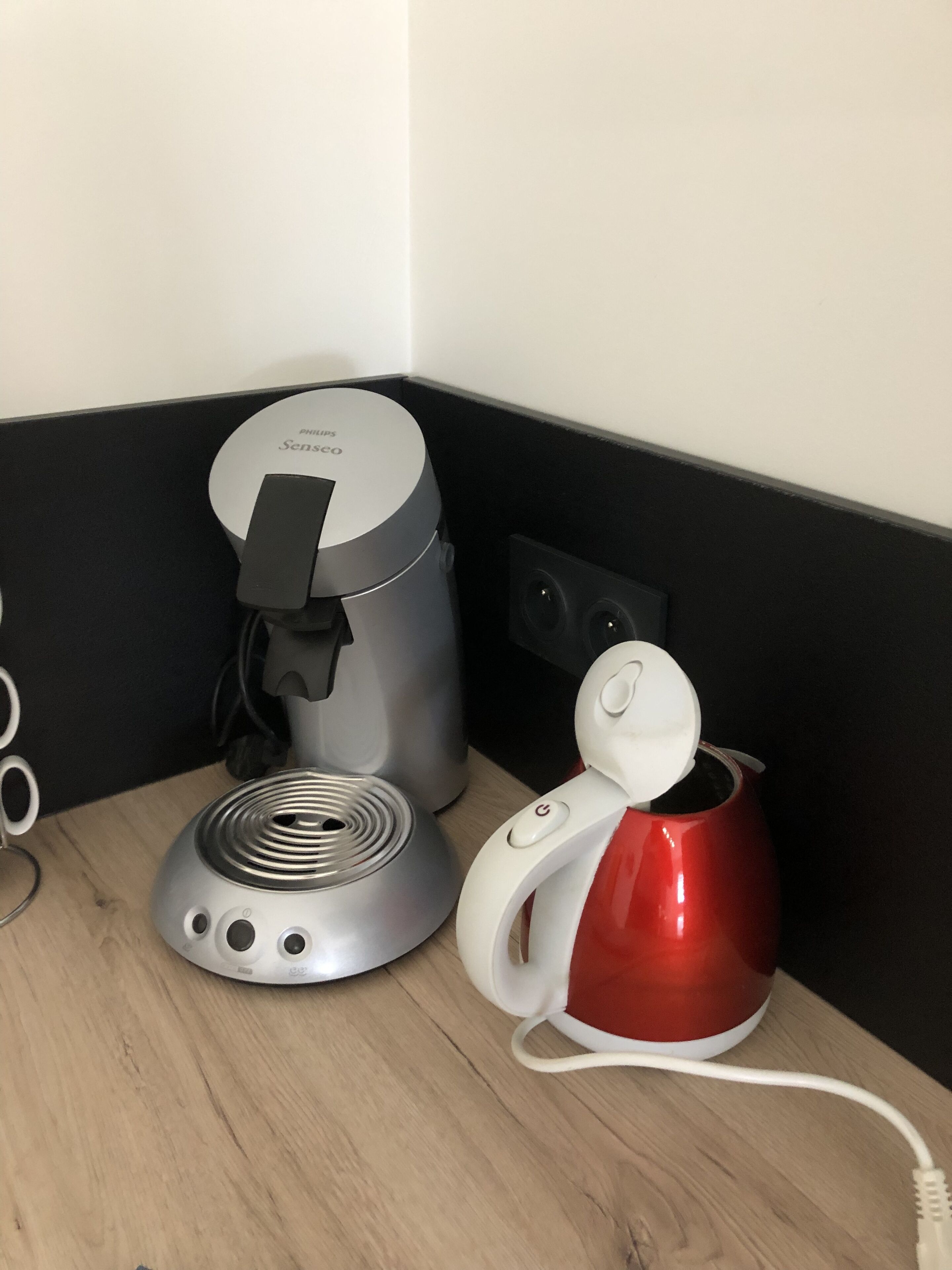 Een koffiezetapparaat en een waterkoker op een houten aanrecht.