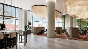 A spacious lobby with high ceilings, large windows, and modern lighting fixtures. - Oakwood Premier Melbourne (Melbourne)