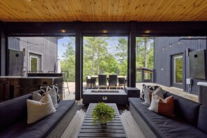 Un espace de vie extérieur moderne comprenant un canapé, un foyer et un ensemble de mobilier de jardin.