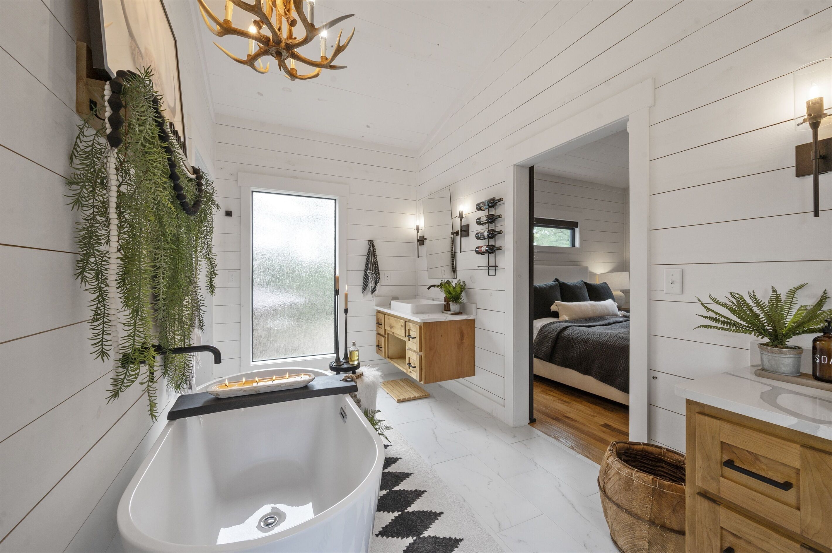 A modern bathroom with a freestanding bathtub, a wooden vanity, and a large window.