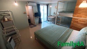 A compact hotel room with a bunk bed, a desk, and a small kitchenette. - The Leaf Service Apartment (Chiang Mai)