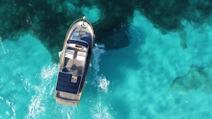 Vista aérea de un barco con cubierta, zona de estar y una pequeña estructura tipo cabina.