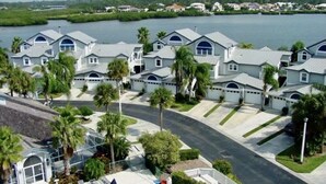 Un quartier résidentiel comprenant plusieurs maisons, une piscine et offrant une vue sur un plan d’eau.
