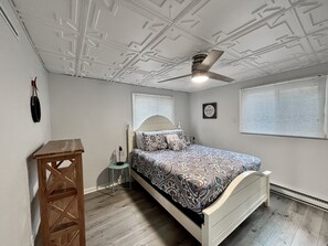 A bedroom with a bed, a ceiling fan, a bedside table, and a wall-mounted lamp. - JOMO - Unit 2 TriTerrace *Relax Lakefront *Enjoy Fam (Rocky Mount)