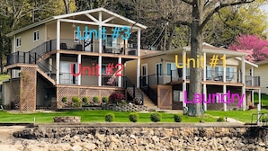 Ein Mehrfamilienhaus mit überdachter Veranda, einer Waschgelegenheit und Blick auf einen Fluss.