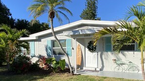 A house with a number 2353, a surfboard, and a bicycle mural.