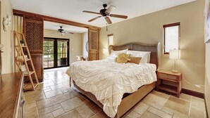 A spacious bedroom with a large bed, a wooden ladder, a ceiling fan, and a view of the outdoors. - Waterfront Oasis w/ Heated Pool and Spa, and Close to Beach! (Fort Lauderdale)