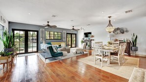 A spacious living area with a large window, a dining table, and a sofa. - Waterfront Oasis w/ Heated Pool and Spa, and Close to Beach! (Fort Lauderdale)