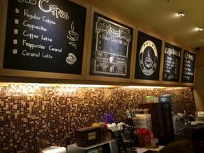 A coffee shop with a chalkboard menu listing items like regular coffee, cappuccino, and latte. - Palmy Hotel (Tanjung Redeb)